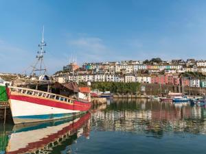 a red and white boat docked in a harbor at 1 Bed in Brixham oc-78520 in Galmpton-on-the-Dart