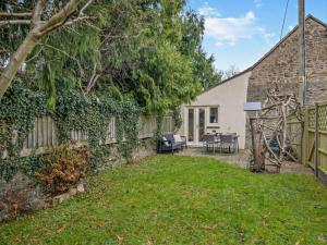 a backyard with a stone wall and a house at 2 Bed in Coleford oc-78181 in Symonds Yat