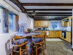 a kitchen with wooden cabinets and a table with chairs at 3 Bed in Belper oc-85797 in Crich