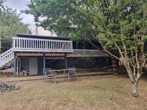 a house with a table and chairs in the yard at Mount Buller Summer & Ski Holiday House The Bower in Merrijig
