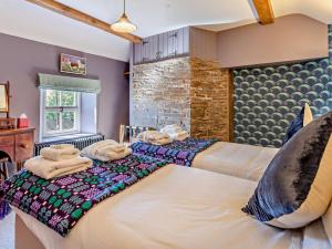 a bedroom with two beds and a brick wall at 4 Bed in Brecon oc-90596 in Bwlch