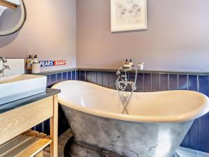 an old tub in a bathroom with a sink at 4 Bed in Brecon oc-90596 in Bwlch +32 photos