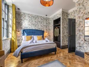 a bedroom with a blue bed and floral wallpaper at 5 Bed in Bideford oc-78690 in Bideford