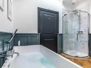 a bathroom with a bath tub and a shower with a black door at 5 Bed in Bideford oc-78690 in Bideford +23 photos