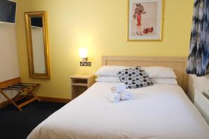 ein Schlafzimmer mit einem Bett, auf dem ein Teddybär liegt in der Unterkunft Feerick's Hotel in Rathowen