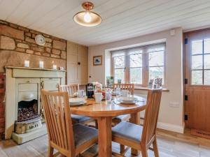 a dining room with a table and chairs and a fireplace at 2 Bed in Lydbrook oc-55961 in Lydbrook +10 photos