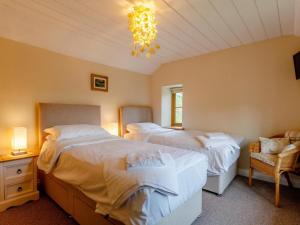 a bedroom with two beds and a chandelier at 2 Bed in Lydbrook oc-55961 in Lydbrook
