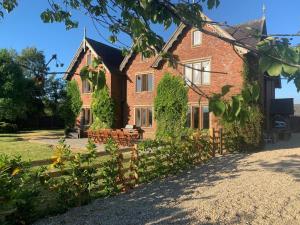 a large brick house with benches in front of it at 8 Bed in Rugeley oc-79321 in Abbots Bromley