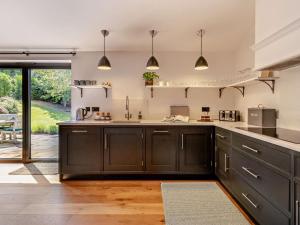 a large kitchen with black cabinets and a patio at 2 Bed in Hereford oc-82095 in Byford