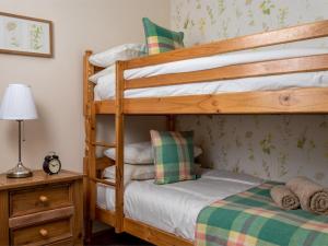 a bedroom with two bunk beds and a lamp at 4 Bed in Brecon oc-bn151 in Devynock