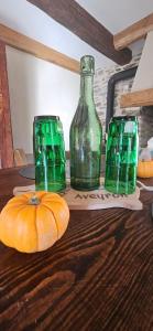 three green glass bottles and a pumpkin on a table at Oustal de Piarelle in Saint-Jean-du-Bruel