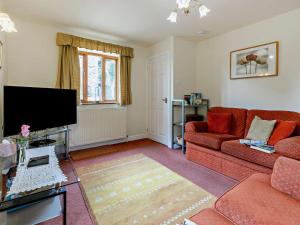 a living room with a red couch and a flat screen tv at 2 Bed in Dronfield oc-pk612 in Barlow