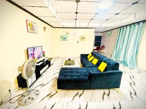 a living room with a blue couch and a fan at Residence Man zele in Man