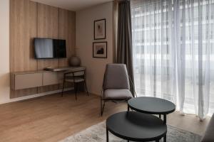 a living room with a tv and a table and chairs at Aparthotel Cosy in Stuttgart