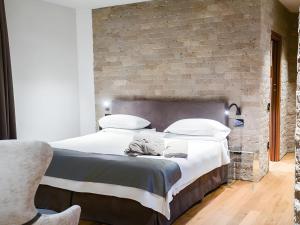 a bedroom with a large bed with white sheets and pillows at Bellavista Terme Resort & Spa in Montegrotto Terme