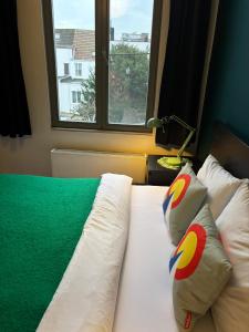 a bed with two pillows and a window at Vintage Lovers Antwerp in Antwerp