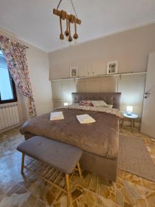 a bedroom with a large bed and a chair at Casa Larissa in Rufina