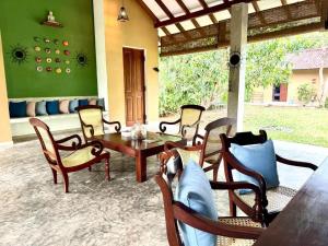 a patio with a wooden table and chairs at Ecoya Riverside Resort in Balapitiya
