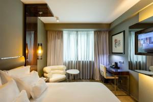 a hotel room with a bed and a desk at Altis Grand Hotel in Lisbon