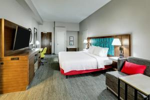 a hotel room with a bed and a flat screen tv at Hampton Inn Beaufort in Beaufort