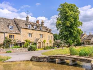 an old stone house with a bridge over a river at 5 Bed in Cheltenham oc-94643 in Lower Slaughter
