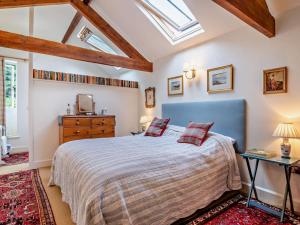 a bedroom with a bed with a blue headboard at 2 Bed in Kington oc-92986 in Lyonshall