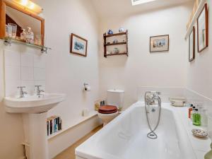 a bathroom with a sink and a tub and a toilet at 2 Bed in Kington oc-92986 in Lyonshall +32 photos