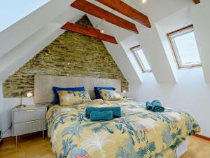 a bedroom with a large bed with a stone wall at 6 Bed in Lechlade oc-93251 in Lechlade