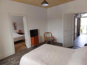 a bedroom with a bed and a television on a table at L atelier du pain in Mesvres