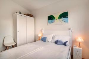 a bedroom with a white bed and a white cabinet at Il Nido in Brenzone sul Garda