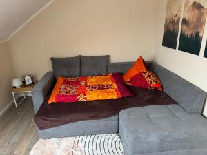 a couch with a blanket on it in a living room at Eifelnest Stadtkyll in Stadtkyll
