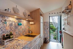 a kitchen with a counter with tiles on the wall at Il Nido in Brenzone sul Garda +19 photos