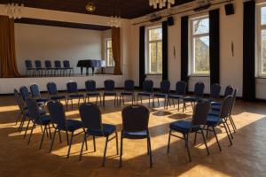 a room with chairs and a table and a piano at KulturHaus Locktow in Locktow
