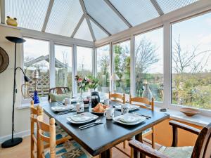 a dining room with a table and some windows at 3 Bed in Brecon oc-93947 in Llanywern