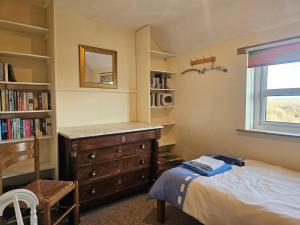a bedroom with a bed and a dresser and a window at 3 Bed in Brecon oc-93947 in Llanywern