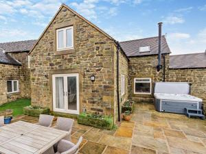 a stone house with a patio with a mattress at 4 Bed in Matlock oc-93830 in Crich