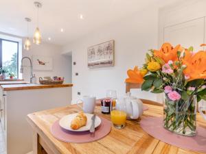 a kitchen with a wooden table with a vase of flowers at 2 Bed in Hope Valley oc-94552 in Bradwell