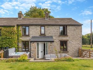 a stone house with a hot tub in front of it at 2 Bed in Hope Valley oc-94552 in Bradwell