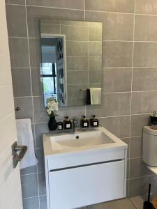 a bathroom with a white sink and a mirror at The Jade, Somerset West in Strand +22 photos