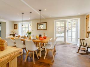 a kitchen and dining room with a wooden table and chairs at 5 Bed in Crickhowell oc-90053 in Crickhowell
