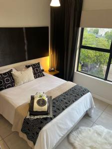 a bedroom with a large bed with a tray on it at The Jade, Somerset West in Strand
