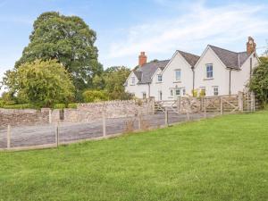 a house with a stone wall and a fence at 5 Bed in Crickhowell oc-90053 in Crickhowell