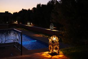 a fire hydrant in front of a pool at night at Maison d'Hôtes Errafiqi in Safi