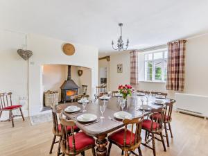 a dining room with a table and chairs and a fireplace at 6 Bed in Okehampton oc-estra in Okehampton