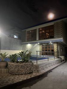 a building with plants in front of it at night at Koenigs Lodging House in Bocaue