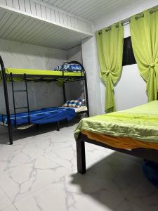 a room with two bunk beds and green curtains at Koenigs Lodging House in Bocaue +3 photos