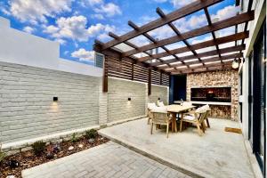 a patio with a table and chairs under a wooden pergola at Rustic Hills #25 in Swakopmund