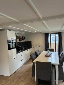 a kitchen and dining room with a table and chairs at Hottub Forest Chalet op de Veluwe! in Putten