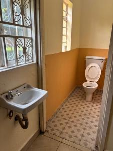 a bathroom with a sink and a toilet at Next Level in Gulu +3 photos