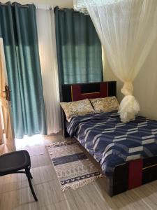 a bedroom with a bed and a window with curtains at Next Level in Gulu